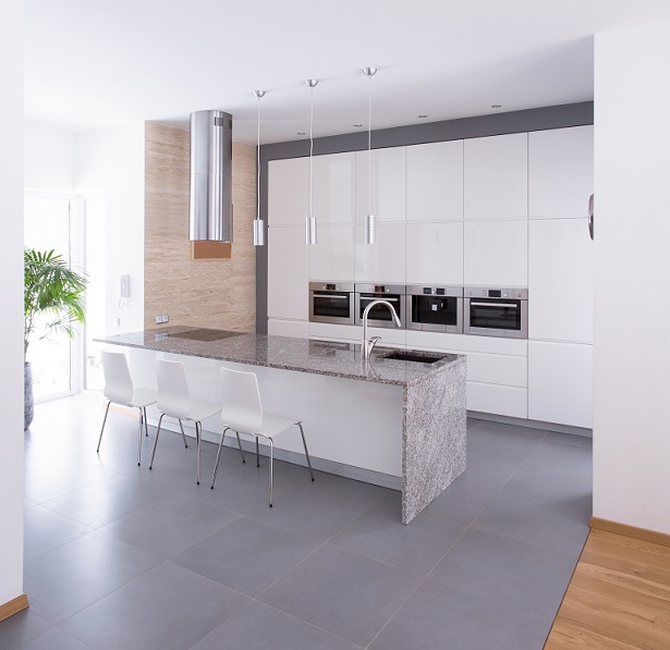 The grey flooring adds depth and refinement to the white kitchen cabinets.