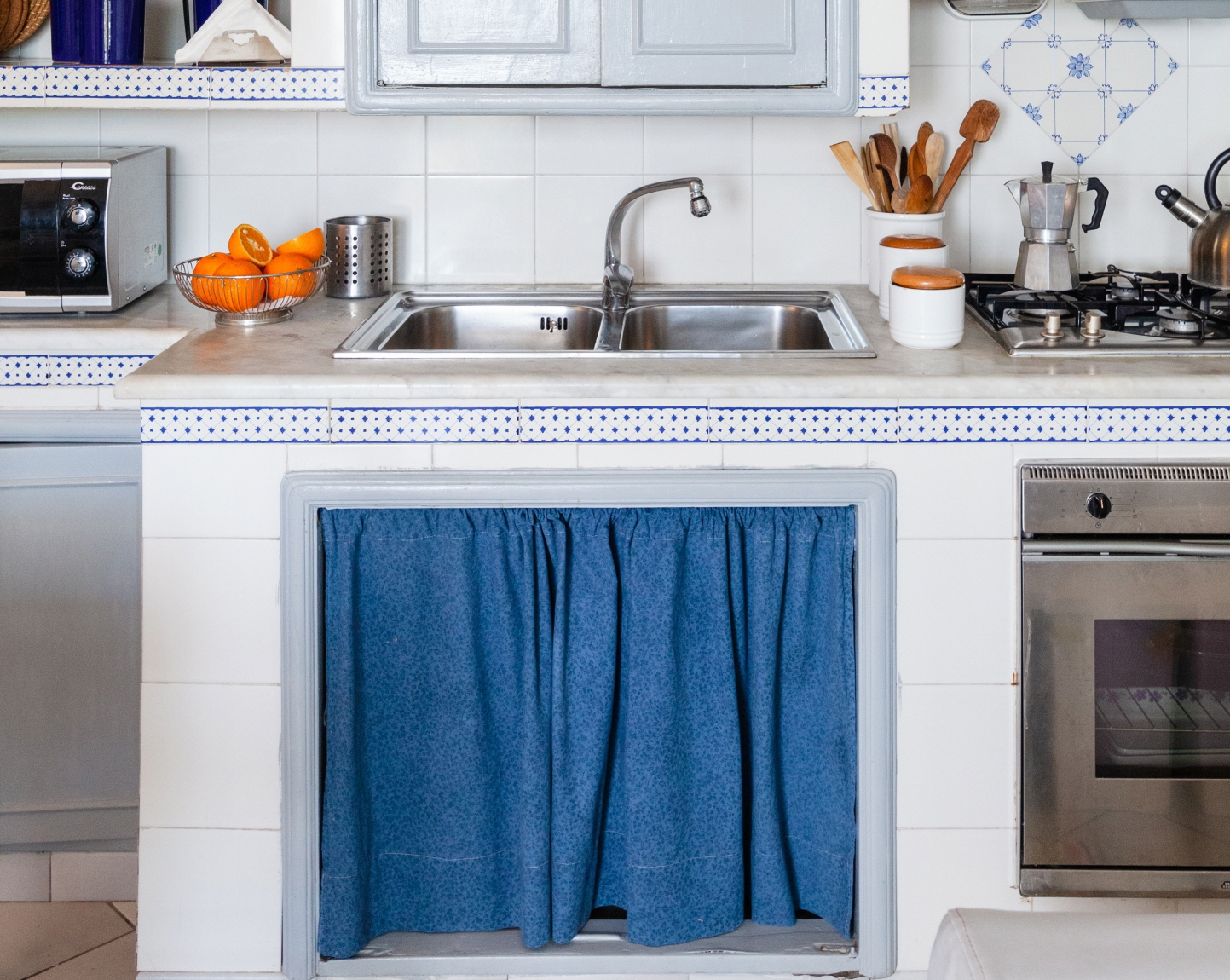 Add charm with a skirt under the sink or open shelves, concealing storage and adding a playful touch to your small kitchen.