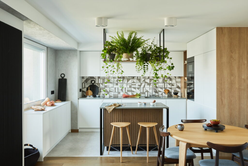 Elevate your small kitchen by installing ceiling-mounted hooks or racks for hanging plants, herbs, or a vertical garden, bringing nature indoors for a fresh touch.