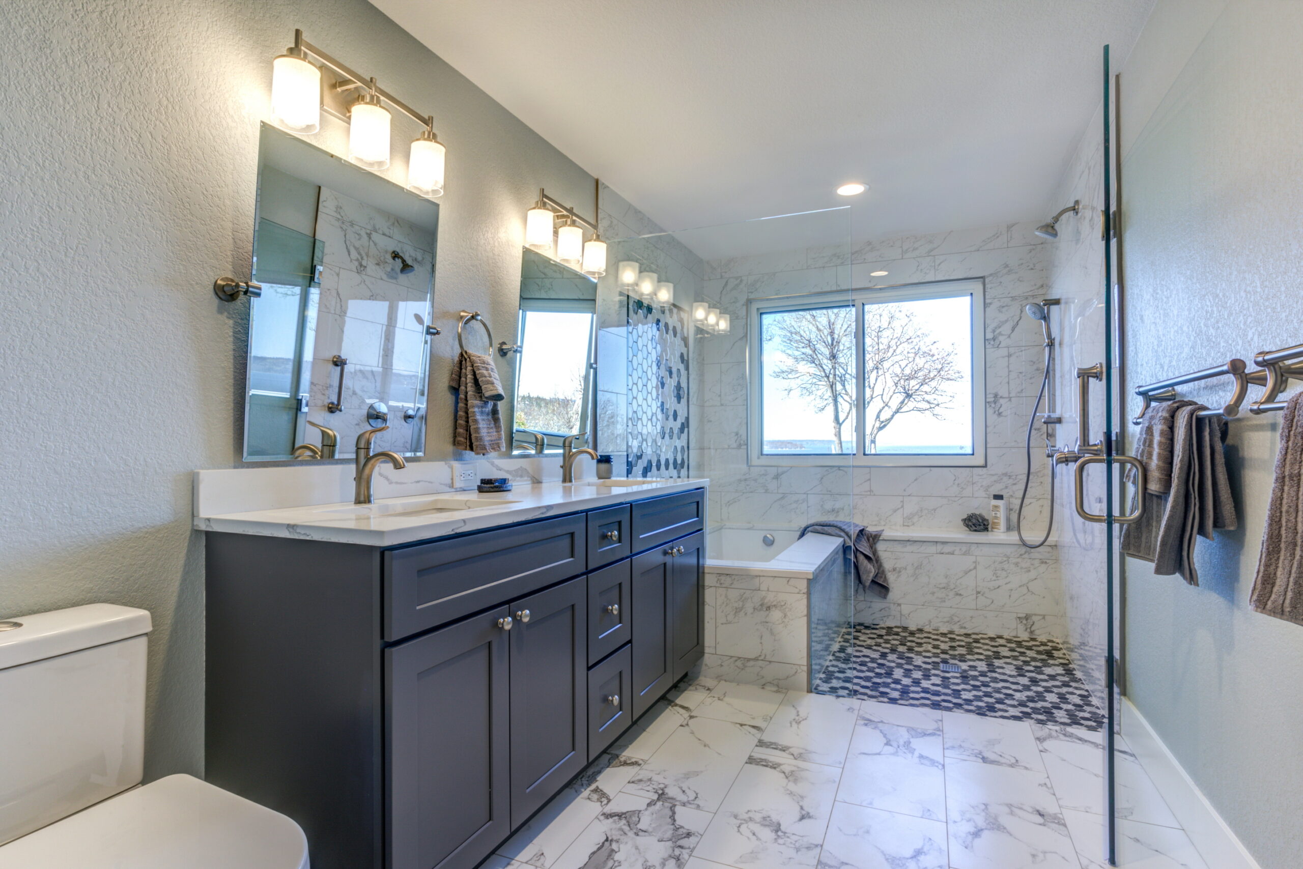 Maximize functionality with sleek, frameless shared mirrors for a modern bathroom.