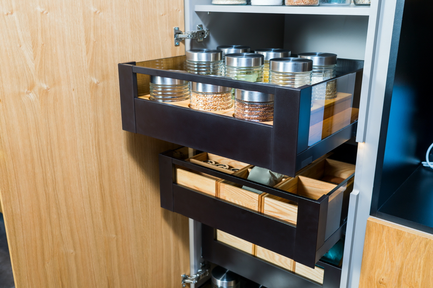 Install pull-out drawers on a track system for convenient access and hidden storage in your pantry, complementing open shelving.